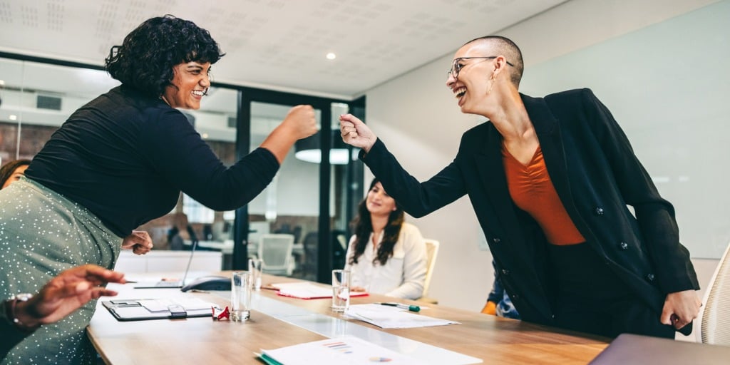 Cheery businesswomen fist bumping each other before a meeting