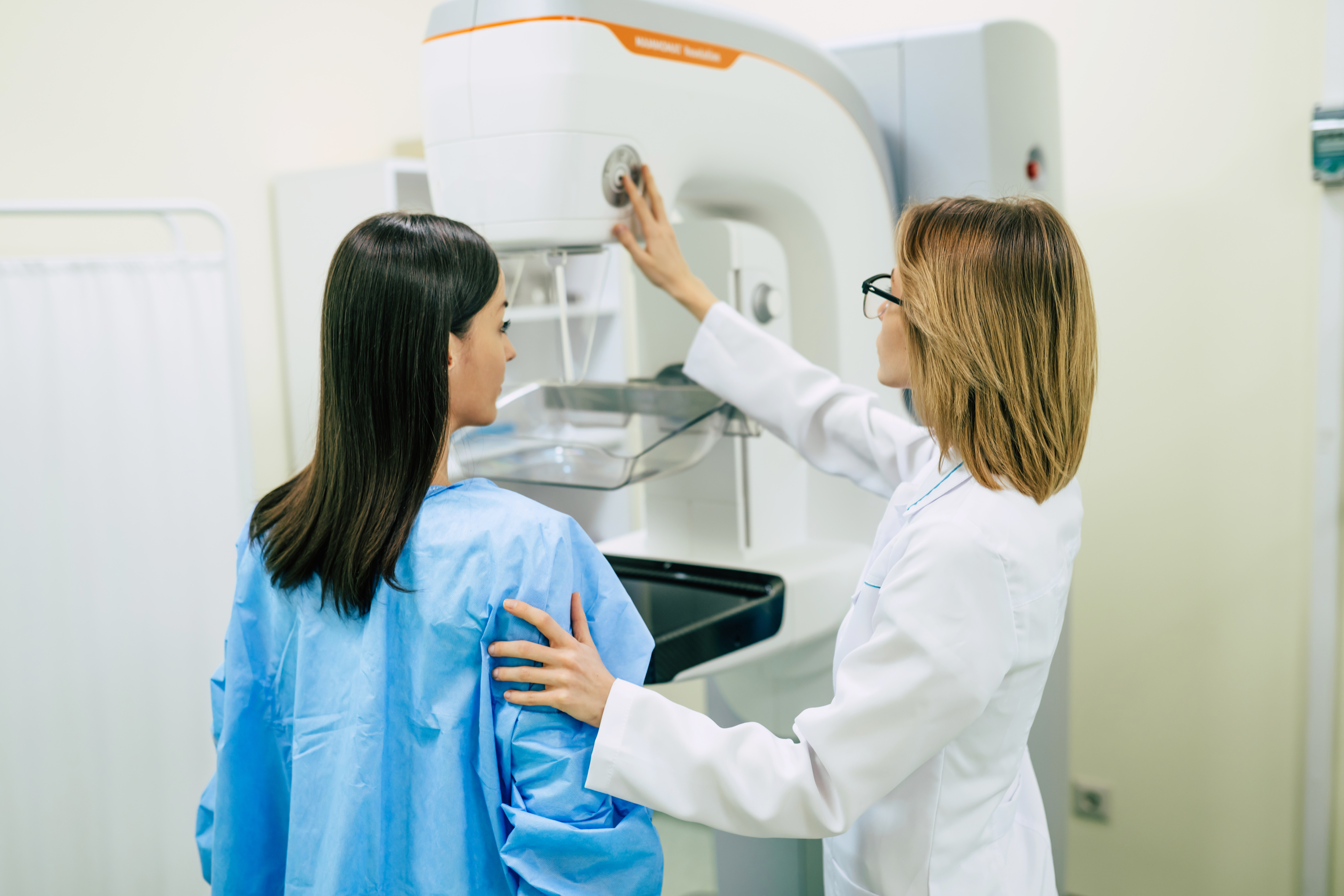 young woman having a mammogram examination by a doctor in a clinical setting