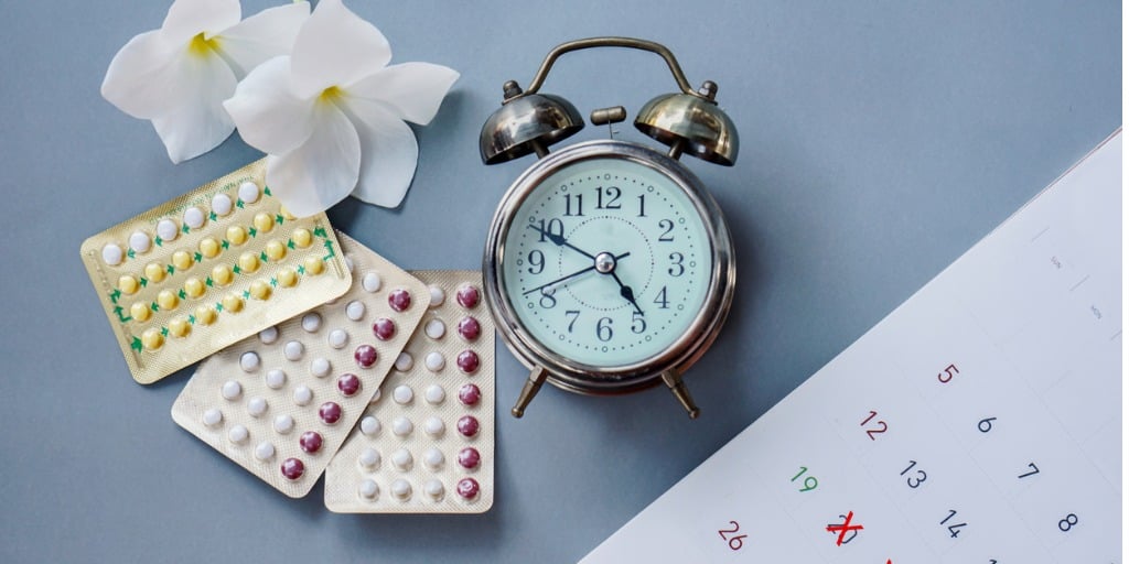 birth control packets next to clock and calendar